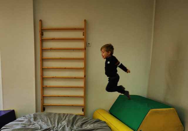 Niño saltando felizmente en la sala de psicomotricidad de la Escuela Infantil EMPI en Murcia, explorando habilidades motoras y emocionales.