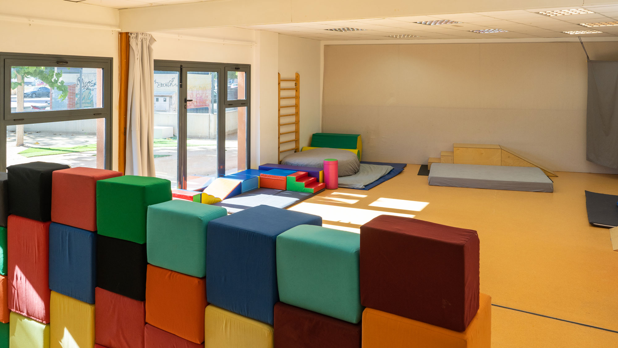 Interior de la Sala de Psicomotricidad de la Escuela Infantil EMPI en Murcia, un espacio acogedor y estimulante diseñado para el desarrollo integral de los niños, lleno de colores vibrantes y materiales educativos.