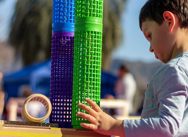 Niño construyendo con materiales no estructurados en Circúbica, expresando su creatividad y desarrollando habilidades motoras y cognitivas en un ambiente de juego estimulante.